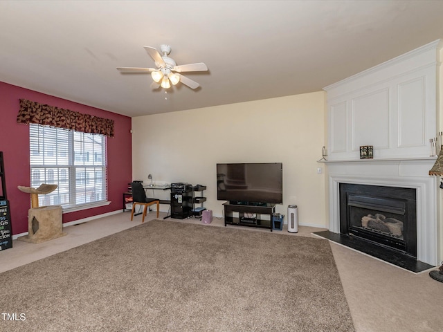 carpeted living room featuring a ceiling fan and a fireplace with flush hearth