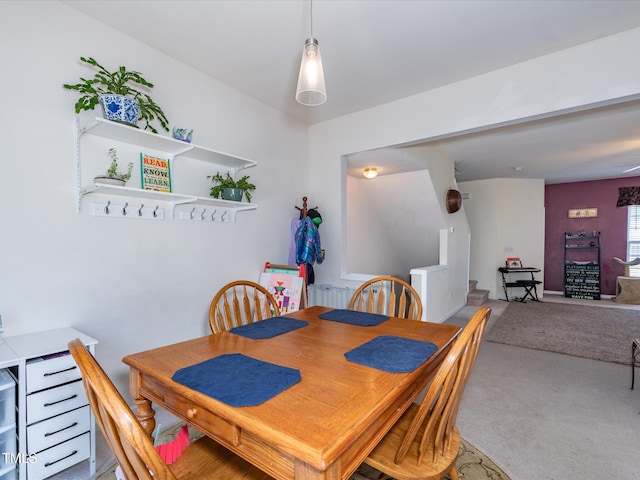 carpeted dining area with stairs