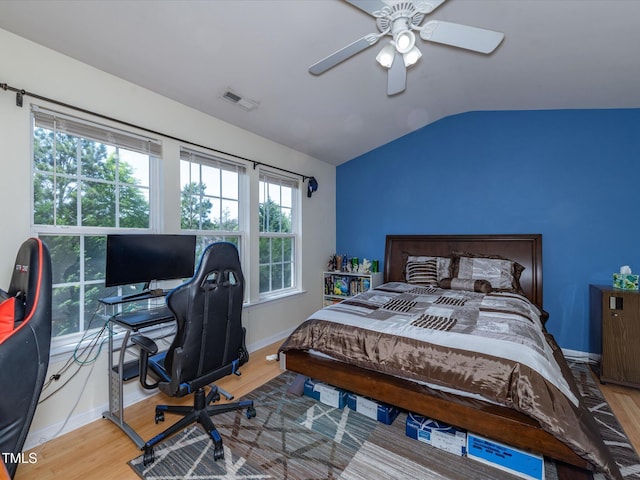bedroom with lofted ceiling, baseboards, wood finished floors, a desk, and ceiling fan
