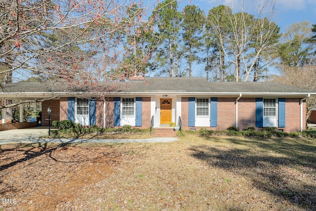 single story home with an attached carport, brick siding, and a front lawn