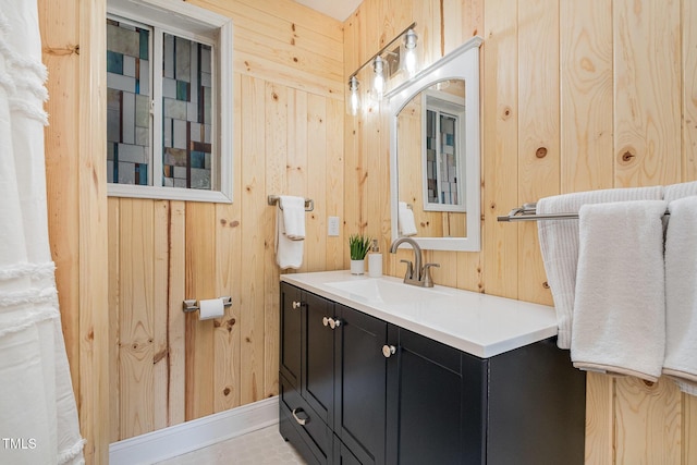 bathroom featuring wooden walls and vanity
