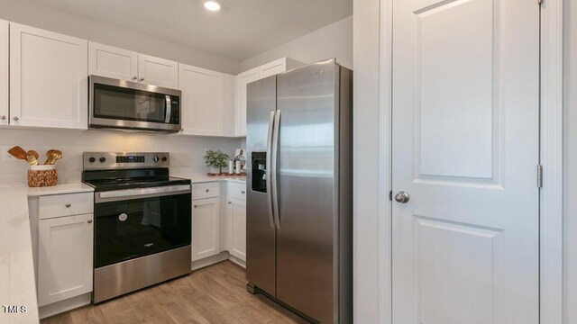 146 Holton St, Smithfield, NC 27577 - kitchen featuring white cabinetry, light countertops, appliances with stainless steel finishes, and light wood-style floors