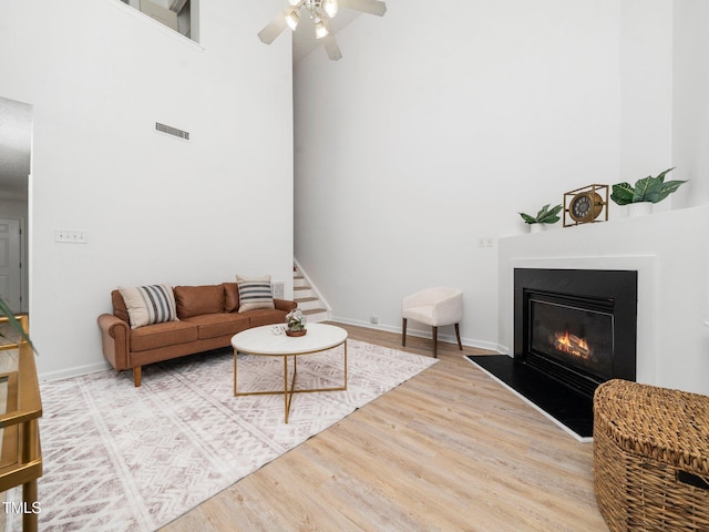 106 Mingocrest Dr, Knightdale, NC 27545 - living area with a fireplace with flush hearth, visible vents, ceiling fan, a towering ceiling, and wood finished floors