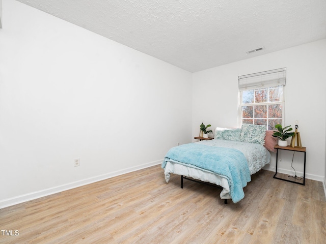 106 Mingocrest Dr, Knightdale, NC 27545 - bedroom featuring wood finished floors, a textured ceiling, baseboards, and visible vents