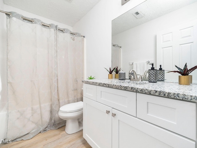 106 Mingocrest Dr, Knightdale, NC 27545 - full bathroom featuring toilet, vanity, wood finished floors, a textured ceiling, and visible vents