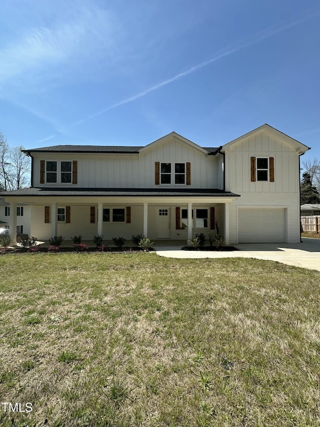 view of front of property with a garage, a front yard, board and batten siding, driveway, and covered porch