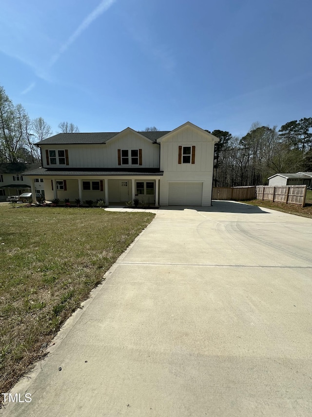 view of front of property with an attached garage, fence, a front lawn, and concrete driveway