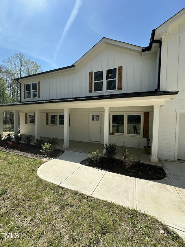 modern inspired farmhouse featuring board and batten siding and a porch
