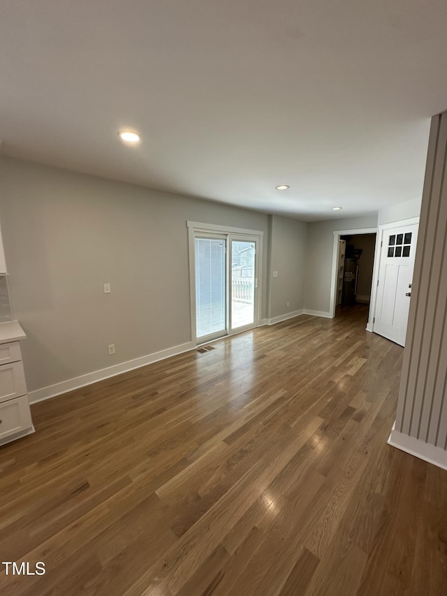 unfurnished living room with baseboards, visible vents, wood finished floors, and recessed lighting