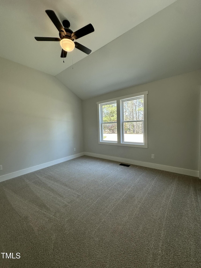 carpeted spare room with baseboards, lofted ceiling, ceiling fan, and visible vents