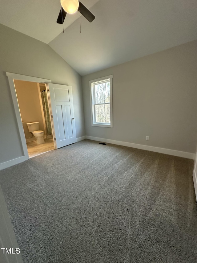 unfurnished bedroom with carpet floors, baseboards, vaulted ceiling, and visible vents
