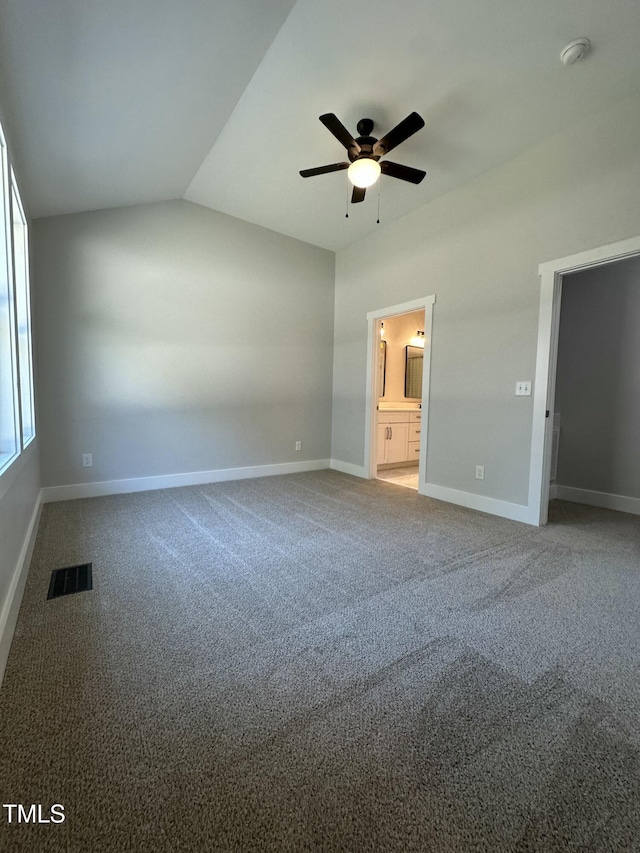 unfurnished bedroom with connected bathroom, vaulted ceiling, baseboards, visible vents, and carpet