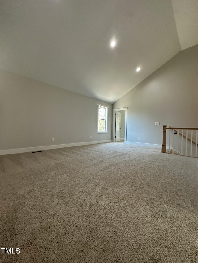 carpeted empty room with baseboards, vaulted ceiling, and recessed lighting