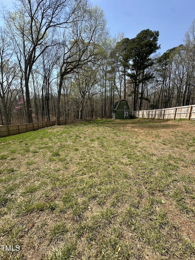 view of yard featuring fence, an outdoor structure, and a barn