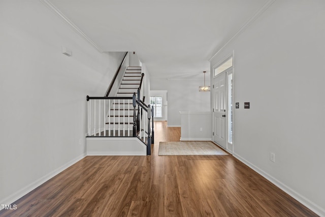 entrance foyer featuring baseboards, stairs, ornamental molding, and wood finished floors