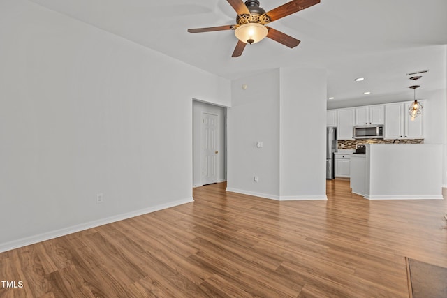 unfurnished living room with baseboards, light wood-style flooring, ceiling fan, and recessed lighting
