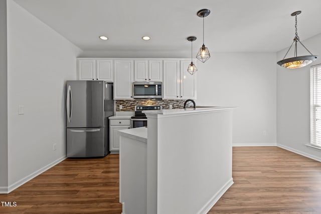 kitchen with decorative backsplash, dark wood-style floors, white cabinetry, and stainless steel appliances