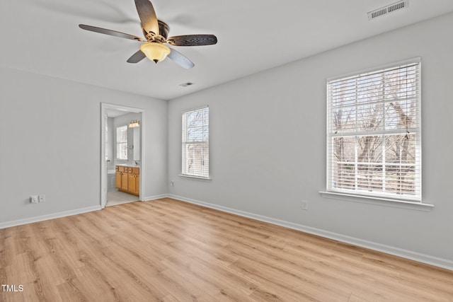 unfurnished bedroom featuring light wood finished floors, baseboards, visible vents, and ensuite bathroom