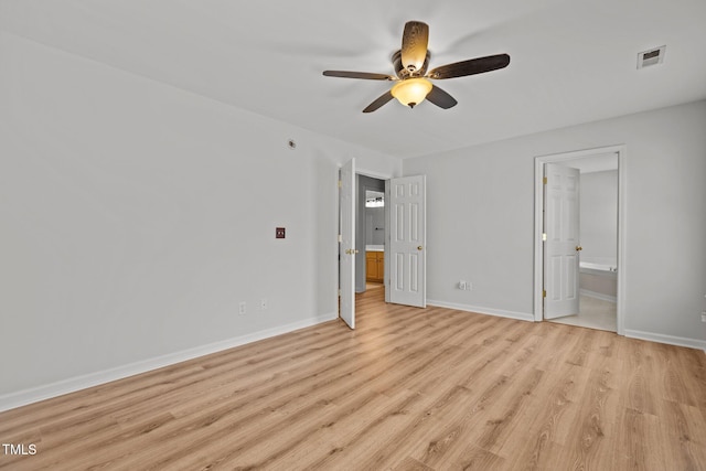 unfurnished bedroom with baseboards, connected bathroom, visible vents, and light wood-style floors