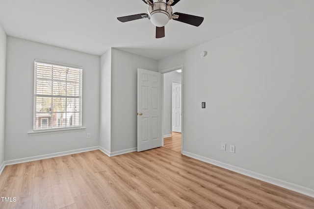 unfurnished bedroom featuring a ceiling fan, light wood-style flooring, and baseboards