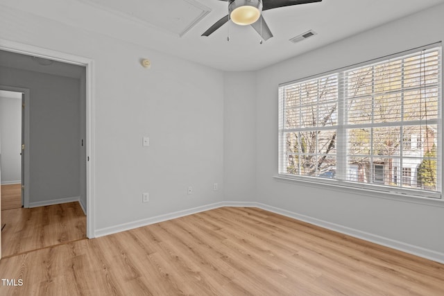 spare room with a ceiling fan, visible vents, baseboards, and light wood-type flooring