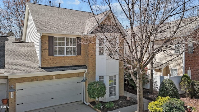 view of front facade with a shingled roof, an attached garage, brick siding, and concrete driveway