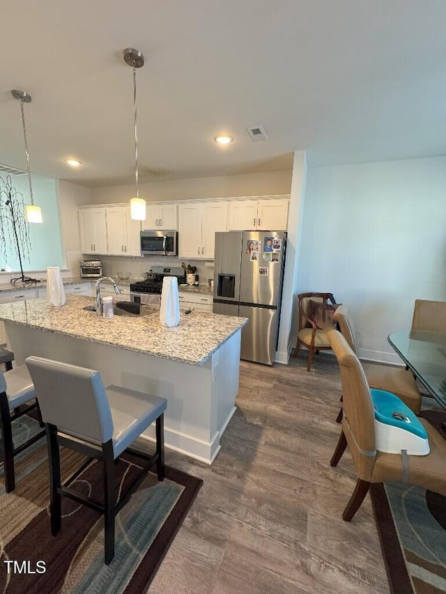 829 S Franklin St, Wake Forest, NC 27587 - kitchen featuring a sink, white cabinetry, a kitchen bar, and appliances with stainless steel finishes
