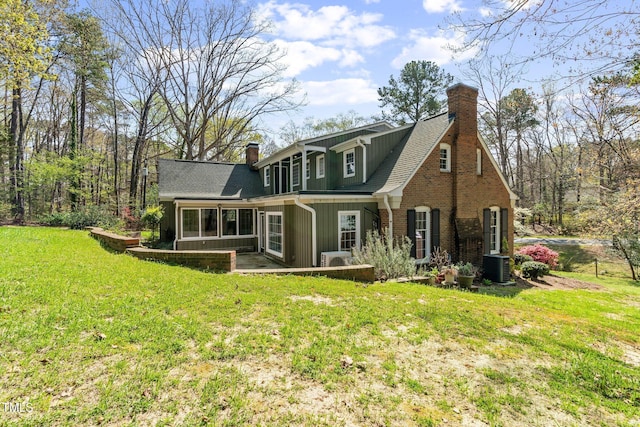 1302 Hermitage Rd, Sanford, NC 27330 - rear view of house featuring a chimney, a shingled roof, central AC unit, and a lawn