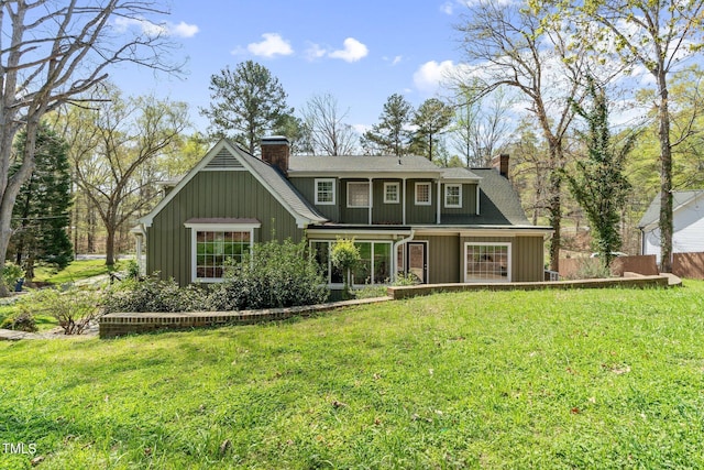 1302 Hermitage Rd, Sanford, NC 27330 - view of front of house featuring a chimney, a front lawn, roof with shingles, and board and batten siding