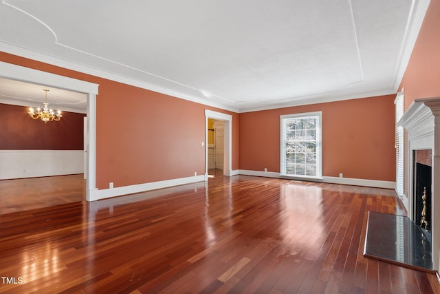 1302 Hermitage Rd, Sanford, NC 27330 - unfurnished living room with baseboards, an inviting chandelier, crown molding, a fireplace with flush hearth, and wood-type flooring