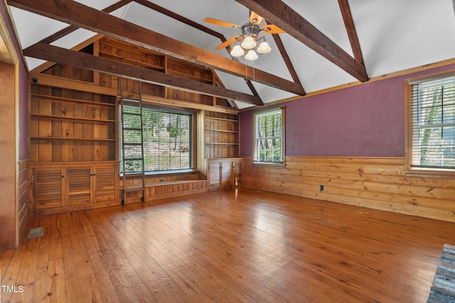 1302 Hermitage Rd, Sanford, NC 27330 - spare room with wood walls, wood-type flooring, beam ceiling, and ceiling fan