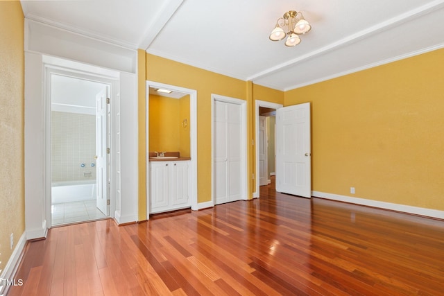 1302 Hermitage Rd, Sanford, NC 27330 - unfurnished bedroom with hardwood / wood-style floors, crown molding, baseboards, and connected bathroom