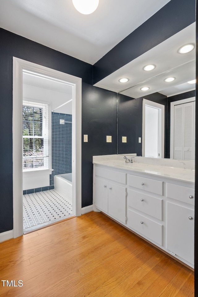 1302 Hermitage Rd, Sanford, NC 27330 - bathroom featuring wood finished floors, vanity, baseboards, and bathtub / shower combination