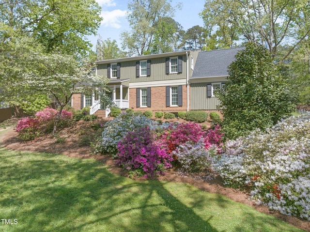 1302 Hermitage Rd, Sanford, NC 27330 - view of front of property featuring board and batten siding, a front lawn, and brick siding
