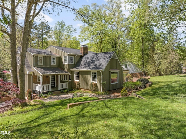 1302 Hermitage Rd, Sanford, NC 27330 - back of house featuring a chimney, a shingled roof, board and batten siding, covered porch, and a lawn
