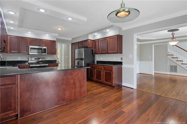 kitchen featuring ornamental molding, dark countertops, stainless steel appliances, and visible vents