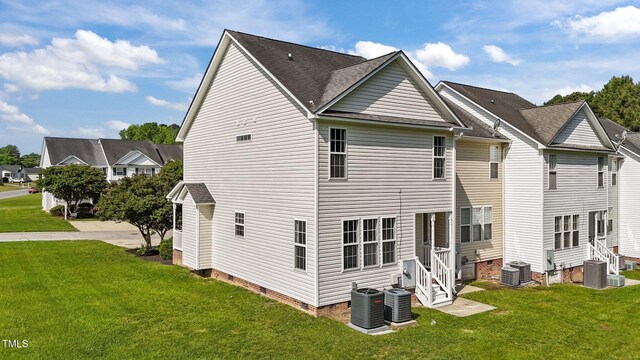 back of house with a lawn and central AC unit