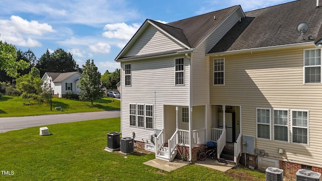 back of house with a lawn and cooling unit