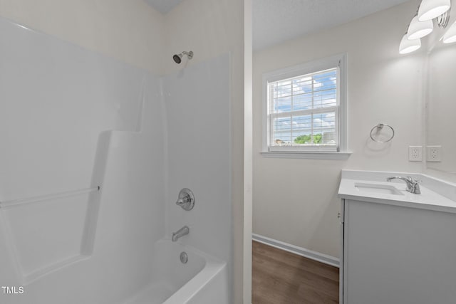 bathroom with shower / bathtub combination, baseboards, wood finished floors, and vanity
