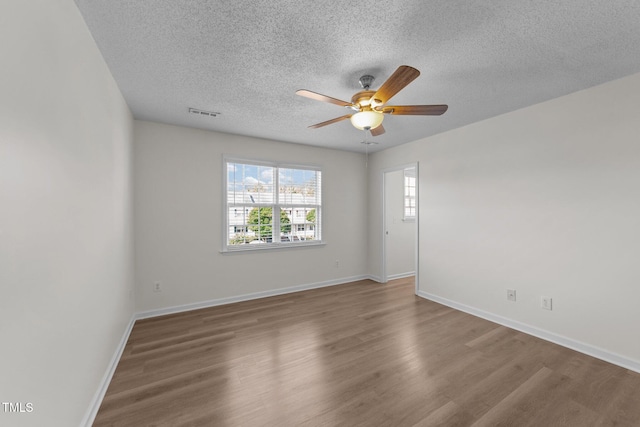 unfurnished room with baseboards, a textured ceiling, ceiling fan, and wood finished floors