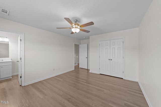 unfurnished bedroom featuring baseboards, light wood-type flooring, and visible vents
