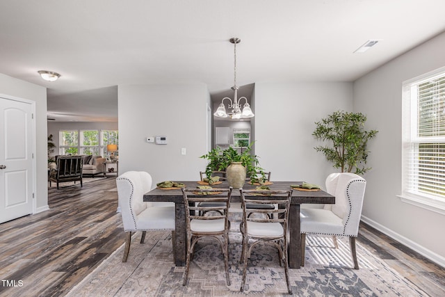 709 Conifer Ct, Creedmoor, NC 27522 - dining room featuring wood finished floors, a chandelier, healthy amount of natural light, and baseboards