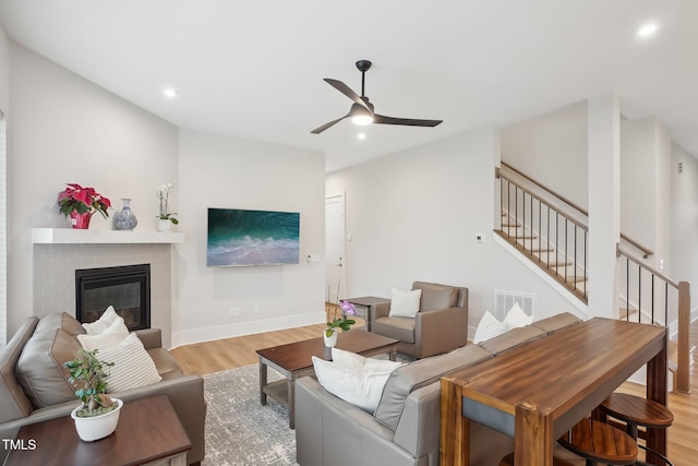 5616 Horsewalk Cir, Raleigh, NC 27606 - living room with a ceiling fan, recessed lighting, stairway, wood finished floors, and a brick fireplace