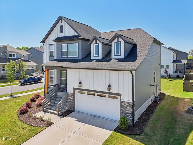 5616 Horsewalk Cir, Raleigh, NC 27606 - view of front of home with a front yard, stone siding, a garage, board and batten siding, and concrete driveway