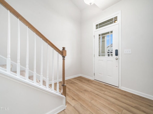 foyer with stairs, baseboards, and light wood-style floors