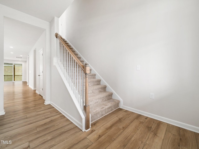 stairs featuring wood finished floors and baseboards