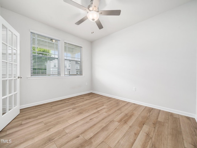 spare room with baseboards, light wood-style flooring, and ceiling fan