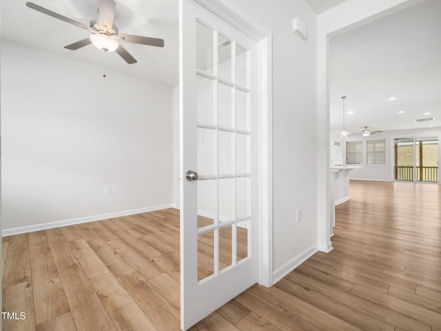 hallway featuring baseboards, recessed lighting, and wood finished floors