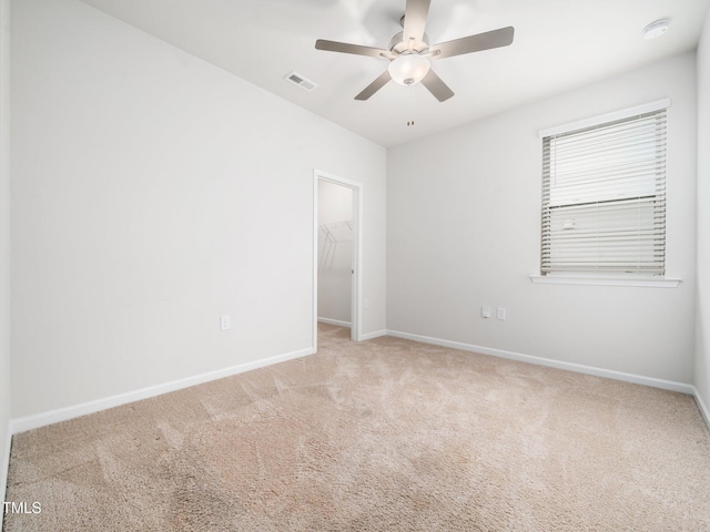unfurnished room featuring baseboards, ceiling fan, visible vents, and carpet