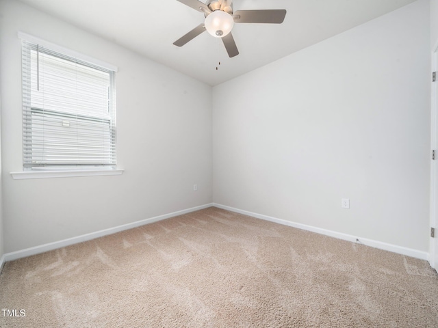carpeted spare room featuring ceiling fan, lofted ceiling, baseboards, and plenty of natural light